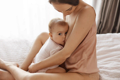 Mutter stillt ihr Baby im Sitzen, ruhige Schlafzimmer Szene, Symbolbild für Wonder Nährstoffe in der Stillzeit.